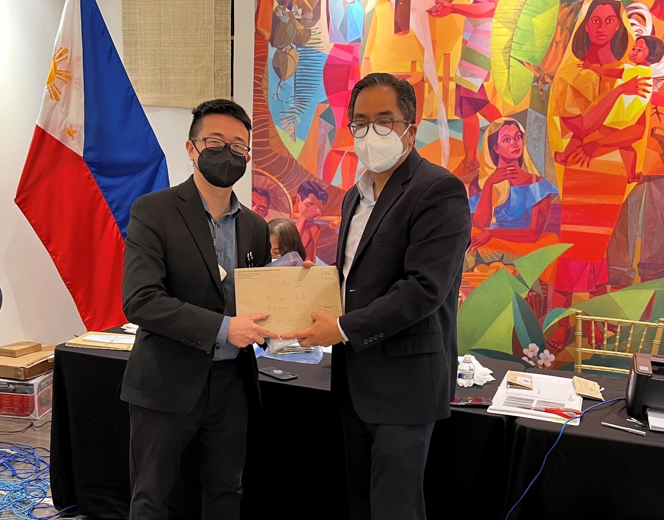 Deputy Chief of Mission Jaime Ramon T. Ascalon Jr. receives the election returns from Consul Ryan Gener